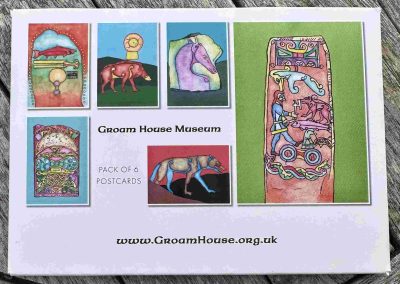 Photograph of a pack of six illustrated postcards from Groam House Museum, featuring colourful artwork inspired by Pictish stones and imagery, including animals, objects and decorative Celtic-style patterns.